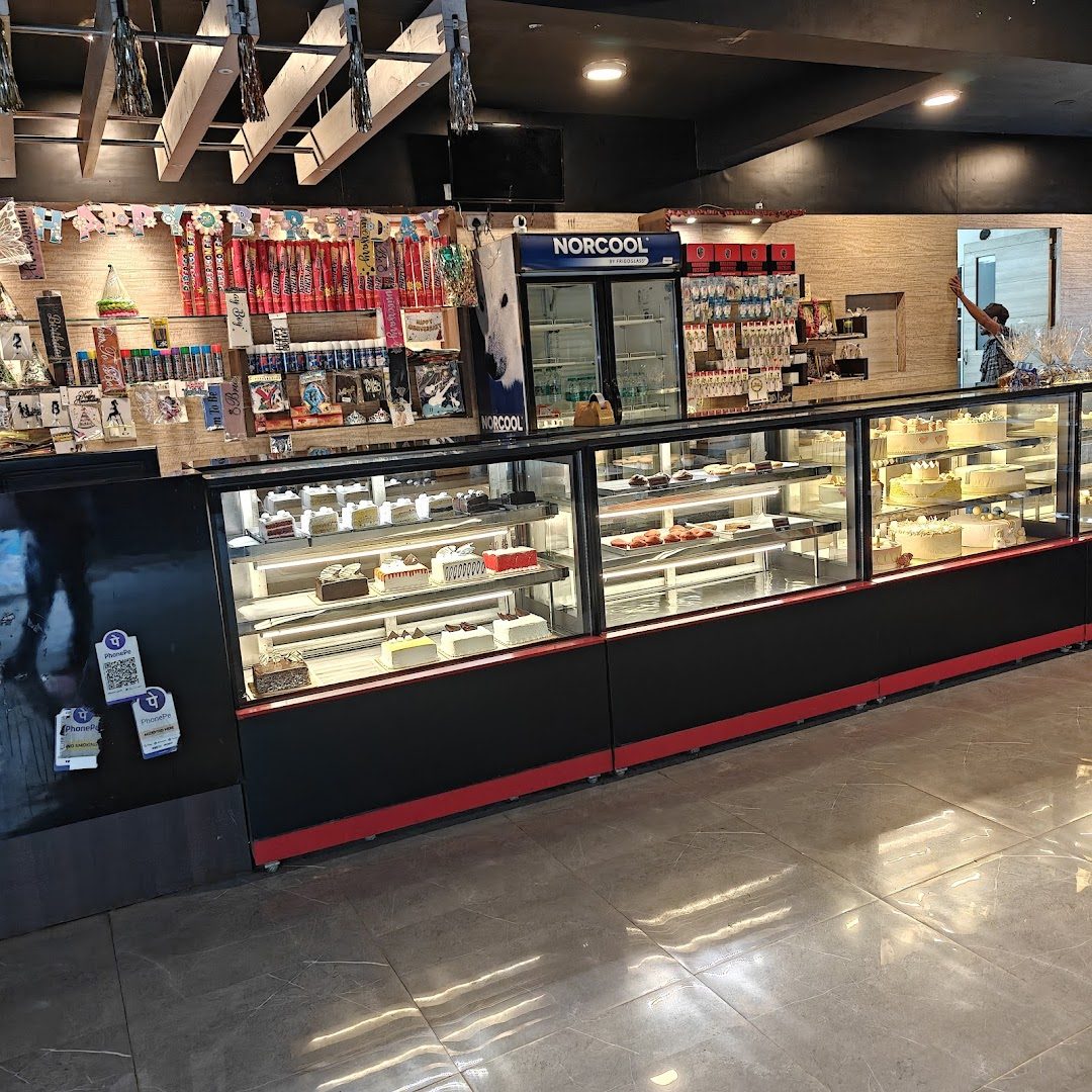 Inside Narayana Pastries — display cases of fresh cakes