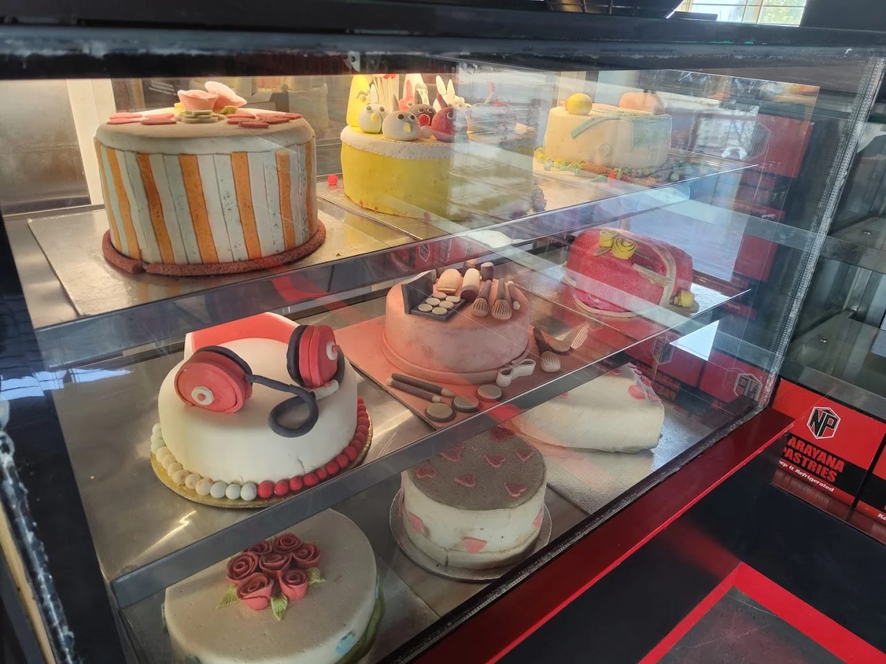 Cake display case at Narayana Pastries — every cake fresh